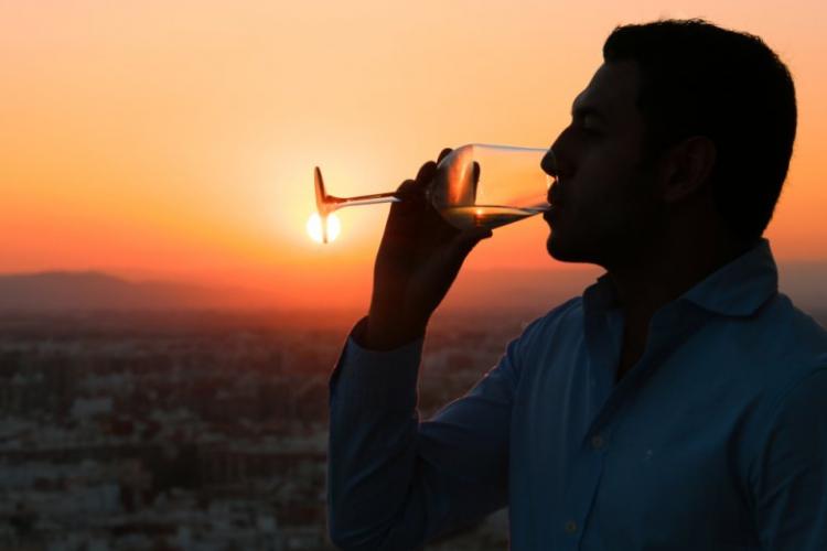 turista bebiendo una copa al atardecer