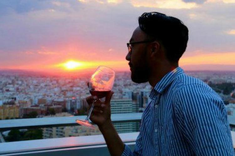 turista bebiendo una copa al atardecer